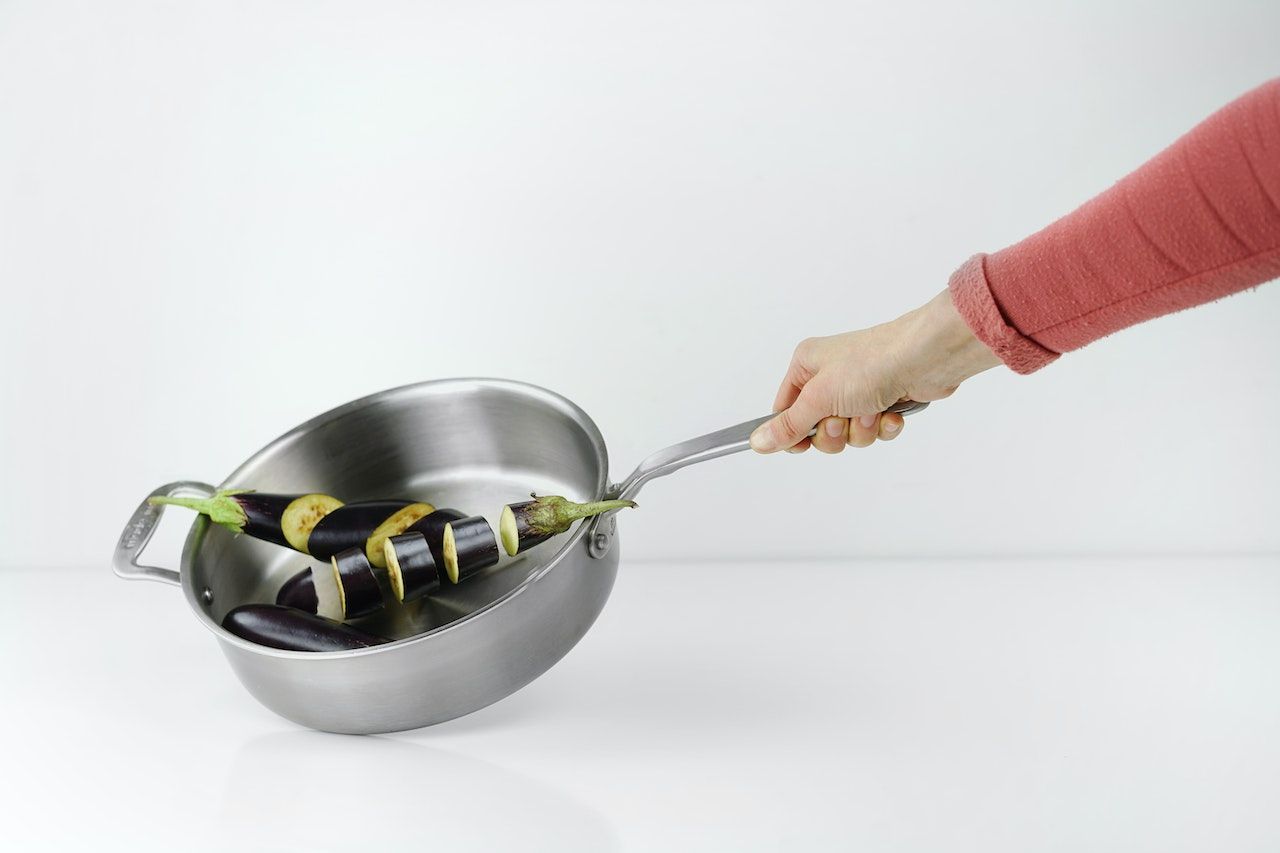 Hand with stainless steel pan